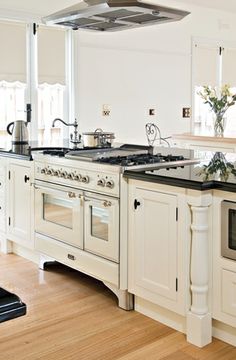 a large kitchen with white cabinets and black counter tops is pictured in this image from the front view