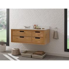 a bathroom vanity with two drawers and a white brick wall in the background, next to a window