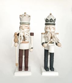 two wooden nutcrackers are standing next to each other