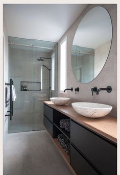 a bathroom with two sinks and a large round mirror above the sink in front of it