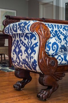 a blue and white couch sitting on top of a wooden floor next to a table