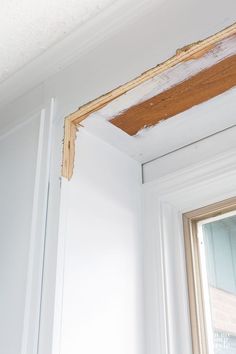 the corner of a room that has been stripped off and is being painted white with brown trim