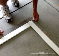 a man is working on an unfinished piece of wood with one hand and the other leg