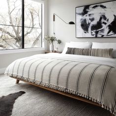 a bedroom with a bed, rug and window