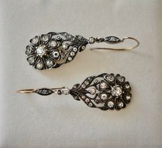 "Striking pair of English Victorian sterling and paste flower dangle earrings, circa 1840s - 1860s. The design is exquisite, comprised of a lovely daisy design of eight heart shaped petals with a larger round paste stone in the middle. There are also eleven more paste stones on the top of the earring. Materials - Sterling silver, paste stones and gold wire. Weight is 9.59 grams. Hallmarks - None. Condition - Very good antique condition. All stones are sparkling and clear. Measurements - Earrings Vintage Earrings With Historical Design, Antique Wedding Earrings With Historical Design, Ornate Historical Design Earrings For Wedding, Ornate Historical Wedding Earrings, Victorian Earrings For Evening, Vintage Rose Cut Diamond Earrings For Formal Occasions, Vintage Rose Cut Diamond Earrings, Historical Design Earrings For Wedding, Victorian Bridal Earrings For Anniversary