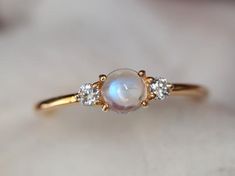 Rainbow moonstone ring, Moonstone engagement ring, stacking ring, Gold moonstone ring, Natural moonstone diamond ring, dainty promise ring Same design can be made also with other custom gemstones per request. Product details:- Solid gold (9k, 14k)- approx 5mm  moonstone round (AAA quality)- 2.5mm Diamonds ( G, VS-SI )- Band size is 1.4mm- Made to order - 8 to 10 business days.Ring size - US 3 to US 9 (for smaller or larger ring size, please contact)Please select your size at the drop down menu. Dainty Moonstone Engagement Ring, Moonstone Gold Ring, Fine Jewelry Stackable Rings For Proposal, Delicate White Gold Diamond Moonstone Ring, Moonstone Rings With Rose Cut Diamonds, Dainty Diamond Moonstone Ring For Wedding, Elegant Moon Shaped Gemstone Rings, Delicate Moonstone Wedding Ring, Elegant Stackable Moonstone Ring With Diamond