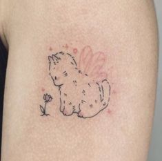 a small cat tattoo on the back of a woman's left arm and shoulder