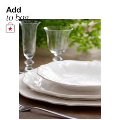 a white plate sitting on top of a wooden table next to two glass vases