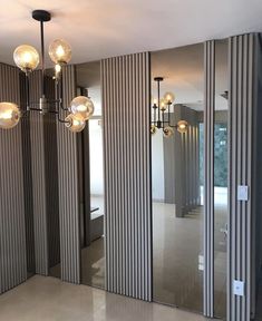 an empty room with mirrors and lights on the wall next to each other in front of a door