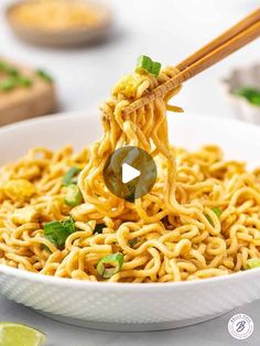 chopsticks holding noodles in a white bowl