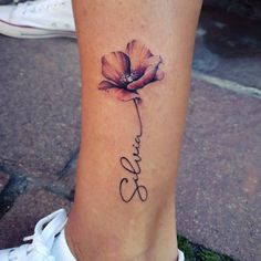 a woman's foot with a tattoo on it that says love and a flower