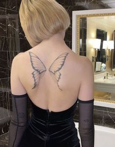 a woman with a butterfly tattoo on her back