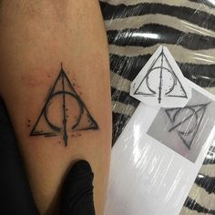 a harry potter symbol tattoo on the left leg, and an image of deathly hall