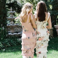 two women in dresses standing next to each other