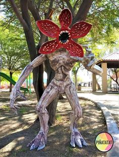 a statue of a man holding a flower in his hand and standing next to a tree