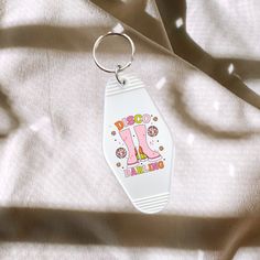 a keychain with the letter j on it is laying on a white sheet