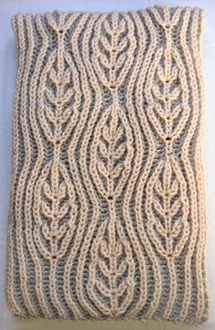 a crocheted pillow made to look like an intricate design on a white surface