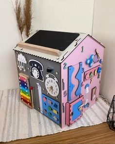 a toy house sitting on top of a wooden floor next to a clock and other items