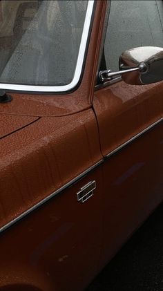 an old brown car parked in a parking lot