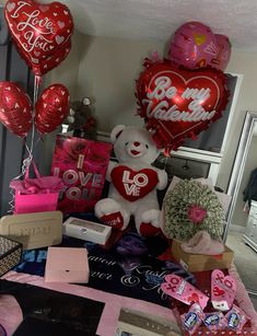 valentine's day decorations and gifts are displayed on a table