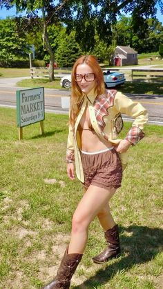 a woman in short shorts and boots posing for the camera with her hands on her hips