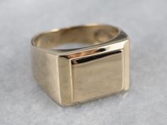 This vintage signet ring is a true classic and is sure to be treasured for years to come! The design is simple and sleek, the beveled rectangle top adding a hint of dimension. This ring has a bold presence on the hand, while still being lightweight and comfortable to wear. Market Square Jewelers works with one of the finest hand engravers in the northeast. With over 30 years of experience, our engraver hand carves lettering, monograms, crests, or patterns in period-specific styles. Choose from o Luxury Timeless Emerald Cut Signet Ring, Luxury Elegant Square Cut Signet Ring, Classic Rectangular Signet Ring Stamped 14k, Modern 14k Stamped Signet Ring For Formal Events, Modern 14k Stamped Signet Ring For Formal Occasions, Square Minimalist Signet Ring For Formal Occasions, Minimalist Square Signet Ring For Formal Occasions, Classic Square Rings With Polished Finish, Square Classic Signet Ring For Formal Occasions