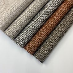 four different colors of fabric sitting on top of a white tablecloth covered in woven material