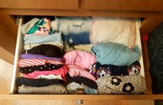 an open drawer filled with clothes and other items