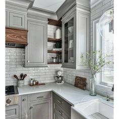 a kitchen with gray cabinets and white counter tops