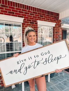 a woman holding a sign that says give it to god and get to sleep