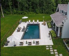 an aerial view of a pool surrounded by lawn furniture