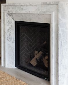 a white marble fireplace with a black mantle