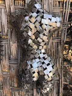 a sculpture made out of metal cubes sitting on top of a wicker wall