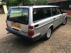 an older silver station wagon parked in front of a house