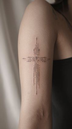 a woman's arm with a cross tattoo on the left side of her arm