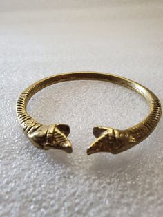 This listing is for an Antique Brass Bangle made in India with double snake heads. It fits comfortably on your wrist and is solid brass, so it is heavy. The engravings are very detailed on both sides of the bangle. There is no marking but on future research I learned they are made in India and are very old. It's very exotic and unique I would stack the bracelet with colored beaded bracelets. I purchased this at an estate sale last summer. It will arrive in a gift box with FREE SHIPPING. Fits up Traditional Adjustable Bracelets With Antique Finish, Traditional Adjustable Bracelet With Antique Finish, Ceremonial Bronze Metal Bracelets, Traditional Adjustable Antique Finish Bracelets, Antique Finish Brass Bracelet In Gold, Adjustable Brass Bracelets For Rituals, Antique Finish Gold Brass Bracelet, Antique Finish Brass Gold Bracelet, Gold Antique Finish Brass Bracelet