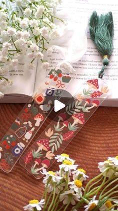 the bookmarks are decorated with flowers and tassels on top of an open book