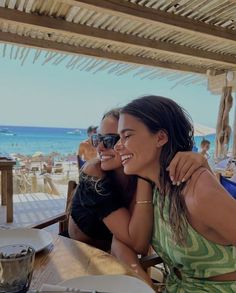 two women sitting at a table with plates of food and drinks in front of them