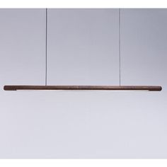 a wooden light hanging from a ceiling in a white room with no one around it