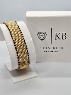 a gold bracelet with black beads and a box on the side that says, i love krisbluu handmade