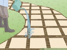 a person pouring water from a watering can into a garden area with tiles on the ground