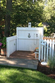 a white fenced in area next to a tree