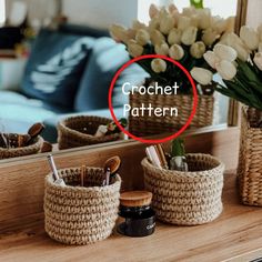 three woven baskets sitting on top of a wooden table next to a vase with flowers in it