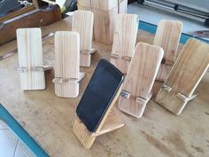 several pieces of wood sitting on top of a table next to a cell phone holder