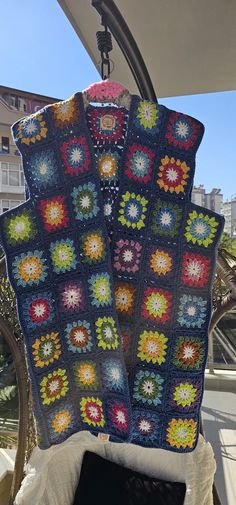 a crocheted blanket hanging from the back of a car