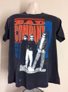 a black shirt with an image of three men standing in front of the words bad company on it