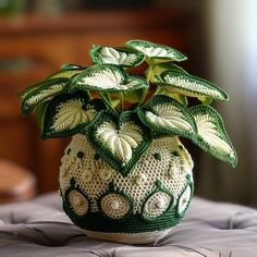 a crocheted potted plant sitting on top of a cushion