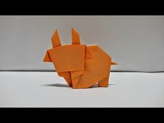 an origami rhinoceros made out of orange paper