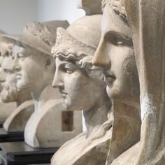 some statues are lined up in a row and one is wearing a headscarf