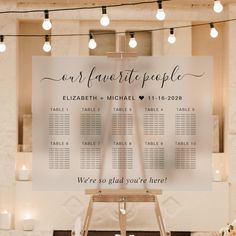 a wedding seating chart is displayed on a easel in front of candles and flowers